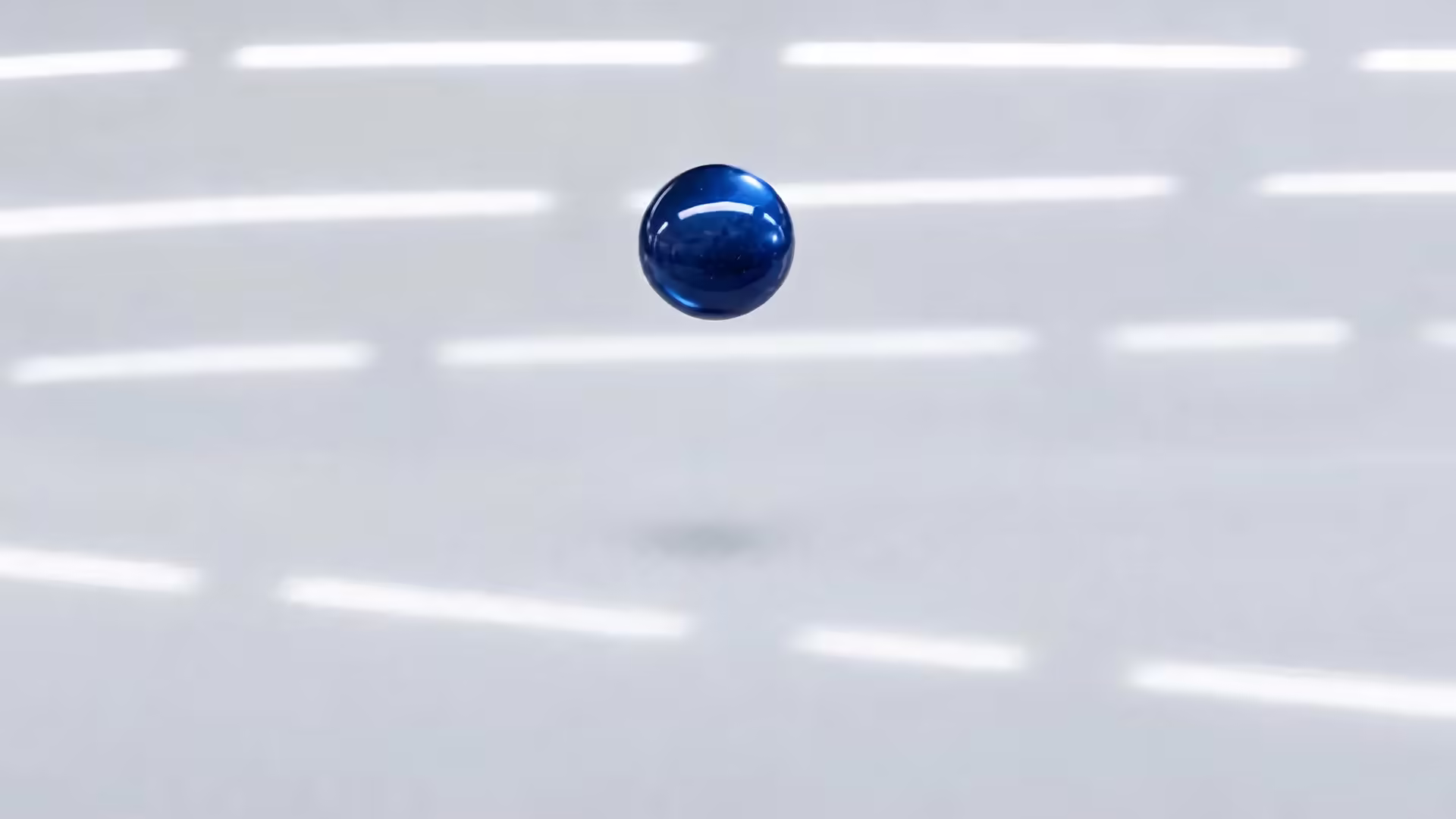 A drop of deep blue metallic paint above a primed car panel